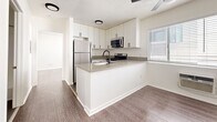 Located at 833 S Berendo St in the Koreatown neighborhood of Los Angeles, this 1-bedroom, 1-bathroom unit offers a clean, modern aesthetic throughout its efficiently designed single-floor layout. The open-concept living and kitchen area forms the heart of the home, featuring wood-look flooring, a textured ceiling, and a ceiling fan that keeps the space comfortable. Natural light filters in through wide, slatted-blind windows, brightening the room and creating an airy feel. A wall-mounted AC unit provides additional climate control.

The kitchen is a standout feature, boasting sleek white shaker cabinetry extending to the ceiling, a peninsula with light quartz countertops and an undermount sink, and a full suite of stainless steel appliances including a gas range, over-the-range microwave, and refrigerator. The peninsula provides both prep space and a casual dining option.

The bedroom is a tranquil, well-proportioned retreat with the same wood-look flooring, a window with natural light, and a full wall of mirrored sliding closet doors that enhance the sense of space. Three closets in total provide ample storage throughout the unit. The bathroom features a clean white vanity, tiled flooring, and a shower-tub combination. The overall design is bright, functional, and move-in ready.