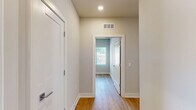 Located at 440 W 14 Mile Rd in Clawson, Michigan, this well-designed 2-bedroom, 1-bathroom unit offers a clean, modern aesthetic across a single floor. Light-toned hardwood flooring runs throughout the entire space, creating a cohesive and airy feel from room to room.

The kitchen serves as a centerpiece of the open-concept living area, featuring white shaker-style cabinetry, granite countertops with subtle speckled detailing, and a kitchen island with a built-in sink. Stainless steel appliances — including a refrigerator, range, and microwave — complement the crisp white finishes. Recessed lighting and a large window overlooking greenery keep the space bright and inviting.

Both bedrooms are comfortably sized, with the primary bedroom offering a generous footprint. Each room features the same light hardwood flooring, neutral gray-toned walls, white panel doors, and windows fitted with horizontal blinds that allow for natural light and privacy. The rooms feel calm and versatile, well-suited for a variety of furniture arrangements.

The bathroom is finished with a white tiled tub-shower surround, maintaining the clean, consistent design language seen throughout the unit. A connecting hallway links the bedrooms and bathroom, adding to the practical flow of the layout. Overall, this unit presents a bright, move-in-ready space with modern finishes and a neutral palette.