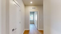 Located at 440 W 14 Mile Rd in Clawson, Michigan, this well-designed 2-bedroom, 1-bathroom unit offers a clean, modern aesthetic across a single floor. Light-toned hardwood flooring runs throughout the entire space, creating a cohesive and airy feel from room to room.

The kitchen serves as a centerpiece of the open-concept living area, featuring white shaker-style cabinetry, granite countertops with subtle speckled detailing, and a kitchen island with a built-in sink. Stainless steel appliances — including a refrigerator, range, and microwave — complement the crisp white finishes. Recessed lighting and a large window overlooking greenery keep the space bright and inviting.

Both bedrooms are comfortably sized, with the primary bedroom offering a generous footprint. Each room features the same light hardwood flooring, neutral gray-toned walls, white panel doors, and windows fitted with horizontal blinds that allow for natural light and privacy. The rooms feel calm and versatile, well-suited for a variety of furniture arrangements.

The bathroom is finished with a white tiled tub-shower surround, maintaining the clean, consistent design language seen throughout the unit. A connecting hallway links the bedrooms and bathroom, adding to the practical flow of the layout. Overall, this unit presents a bright, move-in-ready space with modern finishes and a neutral palette.