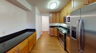 Located at 5321 Randolph Rd in Rockville, MD, this single-floor residence offers a thoughtfully arranged layout with a variety of well-maintained spaces throughout. The kitchen is a standout feature, showcasing warm wood cabinetry, dark granite countertops, hardwood flooring, and stainless steel appliances, including a refrigerator, microwave, and range, creating a functional and attractive cooking environment.

The living area is generously proportioned, with plush carpeting underfoot and a large sliding glass door fitted with vertical blinds that allows abundant natural light and provides outdoor access. The open floor plan visible in the layout connects the living space seamlessly to the kitchen area.

The bedrooms are comfortable and well-lit, each featuring neutral carpet, clean white walls, and windows with blinds that invite natural light. One bedroom includes a built-in shelving closet system, offering organized storage. Additional closet space is present in other rooms as well.

The bathrooms vary in design: one features tile flooring, a dark granite vanity, a tub-shower combination with tile surround, and a textured ceiling, while a secondary bathroom offers a clean, minimal layout with hardwood flooring and chrome fixtures. Overall, the space maintains a clean, neutral aesthetic throughout.