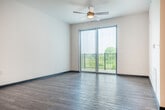 Located at 5124 Central Park Pl in Fitchburg, WI, this single-floor, three-bedroom, one-bathroom unit offers a thoughtfully designed layout with modern finishes throughout. The open-concept kitchen and living area serves as the heart of the home, showcasing white shaker cabinetry, granite countertops, a central island with pendant lighting, stainless steel appliances including a refrigerator, range, microwave, and dishwasher, and a subway tile backsplash. Durable hardwood-style flooring flows throughout the main living areas, complementing the clean, neutral color palette. The living room is bright and airy, featuring a ceiling fan and sliding glass doors that open to a private balcony overlooking the surrounding neighborhood and green landscape. The three bedrooms are carpeted for comfort, each offering a quiet retreat with ample wall space. The full bathroom is finished with granite countertops, white cabinetry with matte black hardware, a tiled shower-tub combo, and neutral tile flooring. A dedicated closet provides additional storage. The unit also includes recessed lighting and a modern entry door, rounding out a well-appointed and move-in ready space.