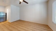 Located along East Ocean Boulevard in Long Beach, California, this efficient single-floor unit offers a thoughtfully arranged layout that makes excellent use of its compact footprint. The interior is finished consistently throughout with warm, light-toned wood-style flooring that lends a cohesive and contemporary feel to the space.

The main living area is bright and open, featuring white walls that maximize the sense of space and a ceiling fan with integrated lighting that provides both airflow and illumination. A window fitted with slatted blinds allows natural light to filter in while offering privacy. The living area flows seamlessly into a kitchenette, which is equipped with a stainless steel refrigerator and a compact countertop workspace—practical features for everyday living.

The unit includes two bathrooms, each maintaining the same clean, white aesthetic found throughout. Both bathrooms feature light wood-style flooring, a toilet, a white vanity with storage, and a window with blinds for natural light and ventilation. One bathroom includes a dedicated vanity counter with a wall mirror, adding a functional grooming area separate from the main fixtures.

Overall, the space presents a clean, move-in-ready environment with a minimalist design that is easy to personalize. Its location near Ocean Boulevard places it within reach of Long Beach's coastal amenities and urban conveniences.