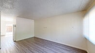Located at 713 E Travis Blvd in Fairfield, CA, this two-story, 2-bedroom, 1-bathroom home offers a practical and well-organized layout split evenly across both floors. The main level features wood-style flooring throughout the living room and kitchen area. The living room is bright and open, with a large window fitted with vertical blinds that allow natural light to filter in and a wall-mounted HVAC unit. The kitchen is efficiently designed with white cabinetry offering ample storage, granite-style countertops, a full-size refrigerator, an electric range, and a double-basin sink — all finished in a clean, cohesive white palette. Upstairs, both bedrooms are carpeted and feature textured ceilings, vertical blind-covered windows that bring in natural light, and neutral wall tones. The primary bedroom includes a sliding closet for storage. A hallway connects the upper-level spaces. The shared full bathroom features wood-style flooring, white cabinetry with granite-style countertops, a white undermount sink, and a full soaking tub/shower combination. The exterior includes a patio area with surrounding greenery, adding a touch of outdoor space to the property.