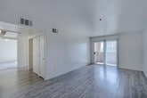 This single-floor, 2-bedroom, 2-bathroom residence offers a clean and functional layout designed for comfortable everyday living. The bright living room features light wood-style flooring and a sliding glass door that opens to an outdoor balcony, allowing natural light to fill the space. Adjacent to the living area, the kitchen is equipped with light wood cabinetry, a gas range, over-the-range microwave, and a full-size refrigerator, all set on matching wood-style flooring. A convenient in-unit washer and dryer can be spotted from the main living area via the hallway.

The primary bedroom is a well-sized retreat with plush carpeting, dual windows that invite natural light and outdoor views of surrounding greenery, and access to a spacious walk-in closet fitted with wire shelving. The second bedroom is equally comfortable, featuring soft carpeting and clean white walls. Both bathrooms are appointed with wood-toned vanity cabinetry, a single-sink countertop, and a full-size soaking tub with shower. Wood-style flooring carries through the bathrooms, tying the overall aesthetic together. The unit's neutral color palette and consistent finishes create a cohesive, move-in-ready atmosphere throughout.
