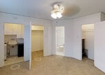 Located at 1001 Sherman Street in Denver, Colorado, this single-floor unit offers a compact and functional layout designed for efficient everyday living. The main living area features neutral carpet flooring and a ceiling fan with light fixture, providing comfortable illumination and air circulation throughout the space. White walls and light-toned surfaces contribute to a clean, bright atmosphere.

A dedicated utility area is accessible directly from the main room, equipped with a utility sink, upper white cabinetry for storage, and space for laundry appliances — offering practical household functionality within a well-organized footprint. Adjacent to this is a spacious walk-in closet, providing ample storage with a full hanging rod and open shelving potential.

The bathroom, also accessible from the main living area, is finished in light tones and includes a toilet and what appears to be a shower/tub combination, maintaining a simple and clean aesthetic consistent with the rest of the unit. The open doorways and connected layout of the rooms promote easy movement throughout the space. Overall, the unit presents a straightforward, move-in-ready environment suited to those seeking a practical residence in the Capitol Hill neighborhood of Denver.