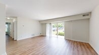 This 790 square foot apartment in Commons At Windsor Gardens offers a thoughtfully designed living space. The single-story layout comprises two bedrooms, a living room, and a kitchen, all finished with a contemporary aesthetic. The primary bedroom, measuring 190 square feet, provides a generous private retreat.

Throughout the apartment, warm-toned wood-look flooring creates a cohesive and inviting atmosphere. Large windows in each room flood the space with natural light, while offering views of the surrounding greenery and community areas. The living room is particularly spacious, with sliding glass doors leading to an outdoor area, perfect for relaxation or entertainment.

The kitchen showcases light wood cabinetry, contrasting nicely with stainless steel appliances including a microwave, oven, and dishwasher. Marble-look countertops add a touch of elegance, while providing ample workspace for meal preparation.

Both bedrooms feature built-in closets with hanging rods for efficient storage. The neutral color palette throughout the apartment allows for easy personalization to suit various tastes and styles. Overall, this apartment combines functionality with modern comfort, offering a welcoming home environment.