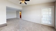 Located in Saint Petersburg, FL, this one-bedroom, one-bathroom residence offers a well-organized single-floor layout designed for comfortable everyday living. The combined kitchen and living area forms the heart of the home, where a peninsula-style breakfast bar with a dark countertop separates the kitchen from the carpeted living space. The kitchen is equipped with warm wood-toned cabinetry, an overhead storage cabinet, a white refrigerator, and a range with an under-cabinet exhaust hood, all set on durable wood-look flooring. The spacious living room features a ceiling fan with integrated lighting and a window that brings in natural light, creating a bright and airy atmosphere. The bedroom is a generously sized retreat finished with plush carpet, a ceiling fan, and a window with outdoor views. It includes access to a walk-in closet outfitted with multi-level wire shelving, offering ample storage. A second closet provides additional organization options. The bathroom features wood-look flooring, a wood-toned vanity with a dark countertop, and a full tub-shower combination with white tile surround. A hallway connects the living areas to the private quarters, completing this efficiently laid-out residence.