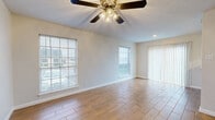 This 1-bedroom, 1-bathroom unit in Austin, TX offers a thoughtfully organized single-floor layout that maximizes every square foot. The living room serves as the heart of the space, featuring wood-look tile flooring laid in a herringbone pattern, neutral painted walls, a textured ceiling, and a ceiling fan with integrated lighting. Multiple windows fitted with horizontal blinds and vertical sliding panels allow generous natural light to fill the room, while a pass-through opening connects seamlessly to the adjacent dining or serving area.

The galley-style kitchen is efficiently designed with white cabinetry, light stone-look countertops, a single-basin sink, a gas range, a built-in microwave, and a dishwasher—providing ample storage and functionality within a compact footprint.

The bedroom offers a comfortable, well-proportioned space with its own ceiling fan, a window with natural light, and wood-look tile flooring consistent with the rest of the unit. A dedicated walk-in closet features built-in shelving and hanging rods on both sides, offering practical storage capacity.

The bathroom includes a white vanity with a light stone countertop, a large mirror with medicine cabinet-style storage, tall built-in cabinetry, and chrome hardware accents, all maintaining the unit's clean, cohesive aesthetic.