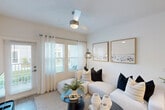 Located at 6136 Blanding Blvd in Jacksonville, FL, this single-story home offers three bedrooms, two bathrooms, and a thoughtfully designed layout across a comfortable footprint. The open kitchen is a standout feature, boasting two-tone cabinetry with white upper cabinets and gray lower cabinets, gleaming granite countertops, a subway tile backsplash, stainless steel appliances including a French door refrigerator with ice maker, gas range, built-in microwave, and dishwasher, plus recessed lighting and light wood-look flooring. The living room is bright and welcoming, with large windows dressed in sheer curtains that invite natural light, complemented by a ceiling fan. The bedrooms are well-appointed, each featuring ceiling fans, natural light from windows, and light wood-look flooring. The primary bedroom includes a spacious walk-in closet with wire shelving and hanging rods. Both bathrooms feature clean white tiled tub-shower combos with brushed nickel fixtures. A dedicated laundry room houses a full-size washer and dryer. Throughout the home, a consistent palette of white walls and light flooring creates a cohesive, modern aesthetic.