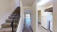 Located at 706 Court Square Dr in Edgewood, MD, this two-story home offers a well-organized layout across two floors. The main level features a bright, open living room with rich hardwood-style flooring and a sliding glass door that fills the space with natural light and provides views of the surrounding greenery. Adjacent to the living room, the kitchen is efficiently designed with dark cabinetry, light countertops, white appliances including a refrigerator, electric range, and over-the-range microwave, and a window that invites additional natural light. A carpeted staircase with a sleek metal railing connects the two floors. The upper level houses the generously sized primary bedroom, which features hardwood-style flooring, a large window for natural light, and a built-in closet with sliding doors. A hallway connects the bedroom to the full bathroom. A dedicated laundry area with a full-size washer and dryer adds notable convenience. Throughout the home, neutral warm tones, clean white trim, and consistent hardwood-style flooring create a cohesive and inviting atmosphere well-suited for comfortable everyday living.