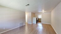 Located at 1295 Donnelly Ave SW in Atlanta, GA, this single-story 2-bedroom, 2-bathroom residence offers a practical and well-organized layout with a clean, modern aesthetic throughout. Light-toned luxury vinyl plank flooring runs consistently across the living areas and bedrooms, creating a cohesive and easy-to-maintain interior. The living room provides a comfortable gathering space, featuring neutral warm-toned walls, a large window that invites natural light and views of the surrounding greenery, and a textured ceiling. The kitchen is efficiently designed with gray cabinetry, granite-style countertops, a classic white subway tile backsplash, and a black electric range — offering ample storage and prep space. Both bedrooms are well-proportioned with neutral gray-toned walls, LVP flooring, and closet access. The primary bedroom includes a direct connection to one of the two bathrooms. The bathrooms are cleanly finished, with one featuring a full tub-shower combination with white tile surround and chrome fixtures, and the second offering a similarly understated, functional design. The overall ambiance is clean, neutral, and move-in ready, with a consistent color palette of warm beiges and soft grays that lends a calm, cohesive feel throughout the home.