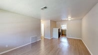 Located at 1295 Donnelly Ave SW in Atlanta, GA, this single-story 2-bedroom, 2-bathroom residence offers a practical and well-organized layout with a clean, modern aesthetic throughout. Light-toned luxury vinyl plank flooring runs consistently across the living areas and bedrooms, creating a cohesive and easy-to-maintain interior. The living room provides a comfortable gathering space, featuring neutral warm-toned walls, a large window that invites natural light and views of the surrounding greenery, and a textured ceiling. The kitchen is efficiently designed with gray cabinetry, granite-style countertops, a classic white subway tile backsplash, and a black electric range — offering ample storage and prep space. Both bedrooms are well-proportioned with neutral gray-toned walls, LVP flooring, and closet access. The primary bedroom includes a direct connection to one of the two bathrooms. The bathrooms are cleanly finished, with one featuring a full tub-shower combination with white tile surround and chrome fixtures, and the second offering a similarly understated, functional design. The overall ambiance is clean, neutral, and move-in ready, with a consistent color palette of warm beiges and soft grays that lends a calm, cohesive feel throughout the home.