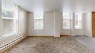 Located at 420 Sherman St SW in Olympia, WA, this one-bedroom, one-bathroom unit offers a well-organized layout across a single floor. The open-concept main living area seamlessly combines the kitchen, dining, and living spaces. The kitchen is equipped with white appliances, including a refrigerator, electric range, and microwave, complemented by warm oak-toned cabinetry. Light gray laminate flooring runs through the kitchen area, transitioning to plush carpet in the living and dining zones. Multiple windows along the exterior walls flood the living space with natural light and offer views of surrounding greenery.

A hallway connects the main living area to the private bedroom, which features soft carpeting and a large sliding-door closet providing generous storage. The bedroom benefits from two windows that invite ample daylight. An additional closet is accessible from the hallway, offering further storage solutions.

The full bathroom is appointed with classic light blue ceramic tile surrounding a full-size soaking tub and shower combination, accented by chrome fixtures and grab bars. Baseboard heating is present throughout the unit, ensuring consistent comfort. The overall aesthetic is clean, neutral, and functional, making this a practical and comfortable home in the heart of Olympia.