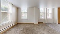 Located at 420 Sherman St SW in Olympia, WA, this one-bedroom, one-bathroom unit offers a well-organized layout across a single floor. The open-concept main living area seamlessly combines the kitchen, dining, and living spaces. The kitchen is equipped with white appliances, including a refrigerator, electric range, and microwave, complemented by warm oak-toned cabinetry. Light gray laminate flooring runs through the kitchen area, transitioning to plush carpet in the living and dining zones. Multiple windows along the exterior walls flood the living space with natural light and offer views of surrounding greenery.

A hallway connects the main living area to the private bedroom, which features soft carpeting and a large sliding-door closet providing generous storage. The bedroom benefits from two windows that invite ample daylight. An additional closet is accessible from the hallway, offering further storage solutions.

The full bathroom is appointed with classic light blue ceramic tile surrounding a full-size soaking tub and shower combination, accented by chrome fixtures and grab bars. Baseboard heating is present throughout the unit, ensuring consistent comfort. The overall aesthetic is clean, neutral, and functional, making this a practical and comfortable home in the heart of Olympia.