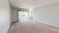 Located at 1900 55th Ave S in Saint Petersburg, FL, this one-bedroom, one-bathroom unit offers a practical and well-appointed layout across a single floor. The living room is a comfortable, open space featuring plush carpeting, neutral gray walls, a textured ceiling, and a sliding glass door that opens onto a private balcony with views of the surrounding greenery, allowing natural light to fill the room.

The kitchen is efficiently designed with light wood-look flooring, white cabinetry, granite-style countertops, and stainless steel appliances including an electric range and dishwasher. A large window provides additional natural light, and a utility panel is conveniently housed within the space.

The generously sized primary bedroom includes soft carpeting, a dedicated closet with hanging storage, and easy access to the rest of the unit. The room is finished with clean white walls and a textured ceiling, creating a calm and functional retreat.

The bathroom features wood-look flooring, a white vanity with granite-style countertop, a full tub-shower combination with white tile surround, and clean, bright finishes throughout.

The entrance provides a welcoming transition into the home. Overall, the unit presents a clean, move-in-ready aesthetic with consistent neutral tones and practical finishes throughout.