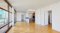 Located in Chicago's vibrant South Loop neighborhood, this well-appointed residence at 40 E Ninth St offers a thoughtfully designed open-concept layout bathed in natural light. The expansive living area is anchored by floor-to-ceiling glass walls with dark-framed sliding doors that open onto a private balcony, offering sweeping city views of the surrounding skyline. Light hardwood flooring runs throughout, adding warmth and continuity across the space.

The kitchen is centrally positioned and features rich wood cabinetry, dark granite countertops, stainless steel appliances including a gas range, built-in microwave, and refrigerator, along with a peninsula that provides additional prep space and separates the kitchen from the main living area. Flush-mount decorative lighting adds a classic touch overhead.

Hallways connect the living spaces to additional rooms, including a versatile secondary room with clean white walls and hardwood floors. The primary bathroom offers a generous layout with warm wood vanity cabinetry, light stone countertops, tile flooring, and a separate shower with tile surround. A secondary bathroom mirrors the same design aesthetic with a single-sink vanity and large mirror.

Throughout, the residence maintains a clean, modern palette of white walls and natural wood tones, creating a bright and cohesive urban living environment.