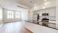 Located on Oneida Alley in the heart of Cincinnati, OH, this well-appointed 2-bedroom, 2-bathroom residence offers a thoughtfully designed single-floor layout that balances modern finishes with urban convenience. Light hardwood-style flooring flows throughout, complementing the clean, neutral color palette that defines each room.

The open-concept kitchen is a standout feature, showcasing white shaker cabinetry, a classic subway tile backsplash, stainless steel appliances, and a generous island topped with dark granite countertops. Pendant lighting above the island adds an elegant touch, while the layout opens seamlessly into the living area, making the space ideal for everyday living and entertaining.

Both bedrooms are well-proportioned and filled with natural light streaming through large, multi-pane windows that frame views of Cincinnati's surrounding cityscape. The primary bedroom offers a notably spacious footprint, while both rooms benefit from ample closet storage.

The two bathrooms are finished to a high standard, featuring geometric patterned tile flooring, white subway-tiled walls, and brushed gold fixtures. One bathroom offers a soaking tub with a glass sliding door, while the second features a walk-in shower. A utility room and additional hallway storage round out the functional layout of this modern urban residence.