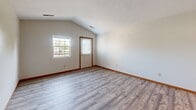 Located at 890 Tallmadge Rd in Kent, Ohio, this single-floor 2-bedroom, 2-bathroom unit offers a practical and comfortable layout. The combined kitchen and living room area serves as the heart of the home, with the kitchen featuring warm wood cabinetry, granite-style countertops, stainless steel appliances including a range, dishwasher, and refrigerator, and durable wood-look vinyl plank flooring. The living area is bright and open, with vaulted ceilings and large windows that invite natural light, complemented by light gray vinyl plank flooring throughout. Both bedrooms are carpeted and generously proportioned, with the primary bedroom offering ample space and large windows with exterior views. The second bedroom also features plush carpet and good natural light. Both bathrooms are finished with wood-tone cabinetry and granite-style countertops, with one bathroom featuring a tub/shower combination and wood-look vinyl flooring. A dedicated closet provides additional storage. Warm wood trim accents and neutral wall tones throughout create a cohesive, move-in-ready aesthetic well-suited to everyday living.