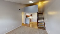 Located at 550 Brandenbush Ln in Columbus, Ohio, this two-story, one-bedroom, one-bathroom home offers a well-organized layout spread across two floors. The main level features a spacious living room with plush carpeting, soaring ceilings, and a skylight that floods the space with natural light. A wood staircase with carpet treads leads to the upper level, while a closet on the main floor provides convenient storage. The open kitchen is thoughtfully designed with rich cherry wood cabinetry, granite-style countertops, black appliances including a range and refrigerator, and light hardwood-style flooring — all framed by a peninsula that connects to the living area. Upstairs, the bedroom is a comfortable retreat featuring vaulted ceilings, soft carpeting, and windows that invite natural light and exterior views. Two closets offer ample storage on this level. The full bathroom is clean and functional, appointed with a granite-top vanity with cherry wood cabinetry, a tub-shower combination with brushed nickel fixtures, and wood-style flooring. Neutral gray tones throughout the home create a cohesive, modern aesthetic, while textured ceilings add a classic touch to this well-maintained Columbus residence.