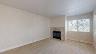 This single-floor, 2-bedroom, 2-bathroom home in Meridian offers a thoughtfully designed layout with a blend of carpet and hardwood-style flooring throughout. The carpeted living room serves as a welcoming focal point, centered around a tile-surround fireplace and framed by windows that fill the space with natural light. Adjacent, the galley-style kitchen is outfitted with dark espresso cabinetry, white countertops, stainless steel appliances including a refrigerator, dishwasher, microwave, and range, and warm hardwood-style flooring — all opening to a combined dining area. Both bedrooms are generously proportioned with plush carpet, large windows overlooking lush greenery, and dedicated closets. The primary bedroom benefits from added convenience with direct access to its own bathroom. Each bathroom features a full tub-shower combination, rich wood-toned vanity cabinetry, white countertops, and hardwood-style flooring. An in-unit laundry area adds everyday practicality. The private patio is a standout feature, offering a serene, tree-canopied retreat with a wood deck and open railing — ideal for enjoying the natural surroundings. Three closets provide ample storage throughout the home.