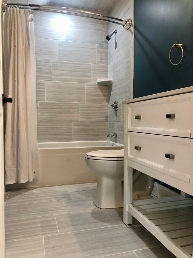 Spacious newly tiled bathroom with washer & dryer hook ups - 83 Cottage St
