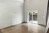 Located at 3772 W Broadway St in Missoula, Montana, this two-story unit delivers a striking industrial-modern aesthetic across two thoughtfully designed floors. The main level features soaring ceilings that amplify the sense of openness, with polished concrete floors running throughout and an open-concept layout connecting the living room, kitchen, and dining area. The kitchen is equipped with stainless steel appliances, granite countertops, pendant lighting, and exposed ductwork that adds an urban loft character. A dramatic open-tread wood staircase with sleek black metal railings serves as a visual centerpiece, leading up to the second-floor loft. The loft, featuring light wood flooring and an exposed wood beam ceiling, offers a flexible space ideal for a home office or additional living area, framed by the same black metal railing that provides an open sightline to the floor below. The bedroom is a comfortable, light-filled retreat with direct patio access, a ceiling fan, and a spacious closet. The bathroom features granite countertops and dark wood cabinetry. Two private patio areas extend the living space outdoors, rounding out this well-appointed and architecturally distinctive Missoula residence.