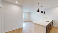Located at 6018 Alpine Vista Cir in Castle Rock, CO, this thoughtfully designed one-bedroom, one-bathroom unit offers a clean, modern aesthetic throughout its efficiently organized single-floor layout. The open-concept kitchen and living area serves as the heart of the home, featuring light hardwood-style flooring, recessed lighting, and a large kitchen island with a white quartz countertop and an undermount sink, illuminated by a trio of sleek black pendant lights. The kitchen is well-appointed with gray shaker-style cabinetry, black hardware, a subway tile backsplash, and stainless steel appliances including a built-in microwave and electric range. The living area flows seamlessly toward windows that invite natural light and frame views of the surrounding Colorado landscape. The bedroom is carpeted for comfort, equipped with a ceiling fan, and features a large window showcasing scenic mountain views. A dedicated closet provides ample storage. The full bathroom is finished with gray cabinetry, a dual-sink white quartz vanity, framed mirrors, and a tub-shower combination with tile surround. Additional highlights include a private balcony access door and a crisp, neutral color palette that enhances the bright, airy ambiance throughout.