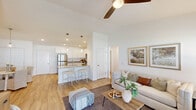 Located at 8495 Hoke Rd in Clayton, Ohio, this single-floor home offers a thoughtfully designed open-concept layout that seamlessly connects the living, dining, and kitchen areas. The living room is highlighted by soaring vaulted ceilings, a ceiling fan, and warm light wood flooring that extends throughout the main living spaces, creating a bright and airy atmosphere.

The kitchen is well-appointed with white shaker-style cabinetry, granite countertops, a breakfast bar with seating, pendant lighting, and a full suite of stainless steel appliances including a refrigerator, range, microwave, and dishwasher. Recessed lighting adds a clean, modern finish.

The bedrooms feature plush carpeting and generous natural light from large windows. The primary bathroom includes an extended white vanity with a quartz countertop, a tub with shower, and wood-look flooring. A dedicated laundry room with upper cabinetry and utility hookups adds everyday convenience.

A hallway leads to a versatile flex space, ideal for a home office or den. Throughout the home, a neutral color palette, clean lines, and consistent finishes contribute to a cohesive and inviting living environment suited for comfortable single-level living.