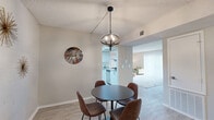 Located at 1132 N Dodge Blvd in Tucson, Arizona, this well-designed single-floor residence offers one bedroom and one bathroom across a thoughtfully organized layout. Light wood-tone flooring flows throughout, complementing a neutral color palette that creates a cohesive, modern feel.

The combined kitchen and living area anchors the home, with the kitchen featuring white shaker-style cabinetry, granite countertops, a classic tile backsplash, and stainless steel appliances. The adjacent dining room is highlighted by an eye-catching globe pendant light, exposed painted brick walls, and room for a round dining set. The living room offers a relaxing atmosphere with a large sliding glass door that fills the space with natural light and provides outdoor access.

A dedicated office with a full-size window offers a functional and quiet workspace. The primary bedroom is generously sized, featuring light flooring, a textured ceiling, and direct sightlines into the en-suite vanity area. The bathroom is equipped with a corner glass-enclosed stand-up shower and wood-look tile flooring. The walk-in closet provides abundant storage with dual hanging rods along multiple walls. Throughout the home, painted brick accent walls and textured ceilings add character to the overall design.