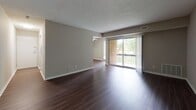 Located at 225 Echelon Rd in Voorhees, NJ, this single-floor residence offers a well-designed layout with a thoughtful blend of modern finishes and comfortable living spaces throughout.

The open living area is a standout feature, showcasing rich, dark hardwood-style flooring that extends seamlessly through the main living and dining spaces. A large sliding glass door floods the room with natural light and provides direct access to a private balcony, offering pleasant outdoor views of the surrounding greenery.

The kitchen is equipped with stainless steel appliances, including a gas range, microwave, and refrigerator. White cabinetry, a decorative tile backsplash, and light countertops create a clean, contemporary aesthetic, while wood-look flooring ties the space cohesively to the rest of the home.

The bedrooms are finished with plush, neutral-toned carpeting, offering a comfortable and quiet retreat. Each room features clean walls, white trim, and closet access, providing ample storage. The textured ceilings are consistent throughout the unit.

The bathroom is notably updated, featuring a full soaking tub with a striking wood-look tile surround in muted gray tones, complemented by brushed nickel fixtures and coordinating floor tile. The overall ambiance of the space is clean, neutral, and move-in ready.