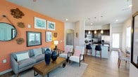 This single-floor residence offers a thoughtfully designed open-concept layout that seamlessly connects the living, dining, and kitchen areas. The living room is a standout space, anchored by a bold terracotta accent wall adorned with an eclectic gallery of framed artwork, a round mirror, and decorative wall pieces. Wood-look flooring flows throughout the main living areas, while a ceiling fan adds practical comfort. The kitchen is well-equipped with dark espresso cabinetry, granite countertops, stainless steel appliances including a refrigerator, range, and microwave, complemented by a tile backsplash and a peninsula with bar seating. A dedicated dining nook is surrounded by large windows that invite an abundance of natural light and outdoor views. The bedrooms feature plush carpeting, ceiling fans, and generous window access to natural light, with one bedroom highlighted by a soothing blue accent wall and a bay window. The bathroom includes a granite vanity, wood-look tile flooring, and a soaking tub with tiled surround. A dedicated laundry area with a full-size washer and dryer adds everyday convenience, rounding out this well-appointed and functional residence.