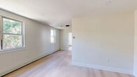 Located at 7900-7922 Fairfield St in Philadelphia's 19152 zip code, this single-floor unit offers three bedrooms and one full bathroom. Throughout the home, light-toned hardwood flooring provides a clean, cohesive look that complements the crisp white walls and bright, neutral color palette.

The spacious primary bedroom is notably generous in size, featuring multiple windows that invite abundant natural light and views of surrounding greenery. Baseboard heating runs along the perimeter, ensuring year-round comfort. The additional two bedrooms are more compact yet functional, maintaining the same clean finishes and light flooring found throughout the unit.

The full bathroom is finished with large-format, light-toned tile covering the walls of the tub surround, creating a sleek and modern aesthetic. A wooden vanity with a white countertop adds a warm contrast, while a framed mirror completes the space.

The kitchen, visible in the floor plan, is efficiently laid out with a range, cabinetry, and a sink, making practical use of the available space. The open flow between rooms enhances the overall sense of accessibility and ease of movement throughout the home. The unit's clean, updated finishes make it a practical and comfortable residence in Northeast Philadelphia.