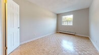 Located at 190 Cedar Street in Cambridge, Ontario, this single-floor, 2-bedroom, 1-bathroom unit offers a practical and functional layout across a comfortable footprint. The space is unified throughout by light-toned parquet hardwood flooring, which lends warmth and visual consistency to every room.

The living room is a well-proportioned space featuring a pendant light fixture and a large sliding window that admits natural light and offers outdoor views. Baseboard heating is present along exterior walls, ensuring year-round comfort. The kitchen is efficiently designed with white cabinetry, ample upper and lower storage, white appliances including a stove, built-in microwave, and dishwasher, and a double sink. A peninsula counter provides a convenient transition into the entry area.

The primary bedroom is a generously sized room with two doorways, one leading to a closet, offering functional storage. The second bedroom is a compact, well-lit room with its own window and baseboard heater. The bathroom features full tile surround in the tub and shower area, a toilet, and a vanity with storage, all finished in neutral tones. The overall ambiance of the unit is clean, neutral, and move-in ready.