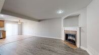 This Arboe Mist townhome offers a well-designed 1130 square foot layout across two floors. The ground level, measuring 580 square feet, hosts an open-concept kitchen and living area. The kitchen boasts wooden cabinetry, granite countertops, and stainless steel appliances, complemented by tile flooring. The adjacent living room features a corner fireplace with a wooden mantel and sleek grey laminate flooring, creating a warm and inviting atmosphere.

Ascending the wooden staircase with metal balusters, you'll find the 550 square foot upper level. The primary bedroom, a generous 190 square feet, includes plush carpeting and a ceiling fan for comfort. Both bedrooms offer ample natural light through large windows with blinds. The bathrooms are tastefully appointed with wooden vanities and modern fixtures.

Throughout the home, neutral wall colors and recessed lighting create a bright, airy ambiance. The property's three full bathrooms, distributed across both floors, offer convenience and privacy. With its thoughtful design and contemporary finishes, this townhome provides a comfortable and stylish living space in the Arboe Mist community.