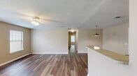 Located at 1920 Goudchaux St in Baton Rouge, Louisiana, this single-story, 4-bedroom, 2-bathroom home offers a well-organized and functional layout. Wood-style flooring runs throughout the entire home, providing a cohesive and easy-to-maintain aesthetic.

The combined kitchen and living room serves as the heart of the home. The kitchen is well-equipped with ample cabinetry in a mix of warm oak and light wood tones, light-colored countertops, a double-basin sink, a white electric range with coil burners, and a full-size refrigerator. A pendant light fixture illuminates the space, and a window allows natural light to flow in. The adjacent living room features multiple windows, a ceiling fan, and a front entry door, creating a bright and airy gathering area.

The four bedrooms are comfortably sized, with the primary bedroom offering generous proportions. Each room features neutral beige walls, wood-style flooring, and windows with blinds that bring in natural light. Select bedrooms include closet access, and the home features two dedicated closets with built-in shelving rods for ample storage.

Both bathrooms are identically appointed, each featuring a full tub-shower combo, a toilet, a vanity with a light countertop, and wood-style flooring. The neutral color palette throughout the home creates a clean, move-in-ready atmosphere. A hallway connects the bedroom wing, enhancing the home's organized flow.