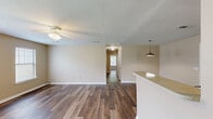Located at 1920 Goudchaux St in Baton Rouge, Louisiana, this single-story, 4-bedroom, 2-bathroom home offers a well-organized and functional layout. Wood-style flooring runs throughout the entire home, providing a cohesive and easy-to-maintain aesthetic.

The combined kitchen and living room serves as the heart of the home. The kitchen is well-equipped with ample cabinetry in a mix of warm oak and light wood tones, light-colored countertops, a double-basin sink, a white electric range with coil burners, and a full-size refrigerator. A pendant light fixture illuminates the space, and a window allows natural light to flow in. The adjacent living room features multiple windows, a ceiling fan, and a front entry door, creating a bright and airy gathering area.

The four bedrooms are comfortably sized, with the primary bedroom offering generous proportions. Each room features neutral beige walls, wood-style flooring, and windows with blinds that bring in natural light. Select bedrooms include closet access, and the home features two dedicated closets with built-in shelving rods for ample storage.

Both bathrooms are identically appointed, each featuring a full tub-shower combo, a toilet, a vanity with a light countertop, and wood-style flooring. The neutral color palette throughout the home creates a clean, move-in-ready atmosphere. A hallway connects the bedroom wing, enhancing the home's organized flow.
