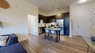 Located at 900 E Brooklyn Village Ave in Charlotte, NC, this well-appointed 2-bedroom, 3-bathroom residence offers a thoughtfully designed single-floor layout. The open-concept living and kitchen area serves as the heart of the home, featuring light wood-style flooring, a ceiling fan, and French doors that lead to a private balcony with lush outdoor views. The kitchen is equipped with dark espresso cabinetry, stainless steel appliances, a tile backsplash, and granite countertops extending to a central island with bar seating — ideal for both cooking and entertaining. The primary bedroom features a bold yellow accent wall, a dedicated closet, and direct access to a well-appointed en-suite bathroom. The en-suite boasts dark cabinetry, granite countertops, and brushed gold fixtures. The second bedroom offers a softer palette with a blue accent wall and a large window with natural tree views. Bathrooms throughout include tile-surround tub-shower combinations and wood-style flooring. A dedicated in-unit laundry area with a stacked washer and dryer adds convenience. Two hallways and multiple closets ensure ample storage. The overall ambiance is modern and residential, with consistent finishes and an inviting, functional flow throughout the space.