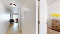 This two-floor residence offers a well-organized layout designed for comfortable everyday living. The entry hallway features tile flooring and plantation-style shuttered closet doors, setting a clean, neutral tone carried throughout the home. A compact electrical panel is conveniently located near the entryway.

The kitchen is efficiently designed with warm wood cabinetry, granite-look countertops, tile flooring, and a full suite of white appliances including a refrigerator, dishwasher, microwave, and range with overhead ventilation. It provides ample storage and functional workspace.

The living area on the lower level is bright and open, featuring tile flooring, a large mirror accent, and access to natural light through vertical-blind windows. A central staircase connects to the upper level, where carpeted bedrooms and a loft-style landing area await. The upper landing is accented with colorful wall art and a small window.

The primary bedroom is generously proportioned with plush carpeting, crown molding, a ceiling fan, and a window with outdoor views. A second bedroom offers similar finishes and comfort.

Two bathrooms serve the home — one featuring a shower with sliding glass doors, and another with a full tub and shower combination, tile flooring, and a vanity with wood cabinetry. Both bathrooms are clean and functional in design.