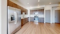Located at 343 E Prehistoric Dr in Pleasant Grove, Utah, this well-designed three-story home offers four bedrooms, three bathrooms, and a thoughtful layout spread across three distinct levels. The entry level features light luxury vinyl plank flooring, large windows that invite abundant natural light, and direct access to the main living areas. The main floor hosts an open-concept living room, dining area, and kitchen, all unified by warm light wood-tone flooring and recessed lighting. The kitchen is equipped with rich walnut-toned cabinetry, stainless steel appliances including a French door refrigerator, built-in microwave, and electric range, all complemented by clean white countertops. Carpeted staircases connect the three floors, leading to the upper level where the bedrooms are concentrated. The generously sized primary bedroom benefits from plentiful natural light through large windows. All bedrooms feature plush carpet flooring and recessed lighting. Six well-organized closets, including a walk-in with built-in shelving and dual hanging rods, provide ample storage. The three bathrooms are finished with light wood-look flooring, wood-toned vanities, white countertops, and full tub-shower combinations. A dedicated laundry space and hallway complete this clean, modern home.