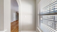 This contemporary 1000 sq ft apartment offers a harmonious blend of style and functionality. The heart of the home is a sleek kitchen, boasting pristine white cabinetry, stainless steel appliances, and a distinctive hexagonal tile backsplash. The kitchen's island provides additional prep space and casual dining options.

The living area is bathed in natural light, courtesy of large French doors leading to a balcony. Warm wood flooring flows throughout the main living spaces, creating a cohesive and inviting ambiance. The primary bedroom, measuring 150 sq ft, features plush carpeting and a ceiling fan for comfort.

Both bathrooms showcase modern fixtures, including floating vanities with ample storage. The apartment's thoughtful design incorporates built-in shelving and walk-in closets, maximizing storage potential. Three hallways ensure easy navigation through the space.

The apartment's neutral color palette, predominantly in soft grays and whites, allows for versatile decorating options. Ceiling fans in main areas provide air circulation, while recessed lighting adds to the contemporary feel. This well-appointed apartment offers a perfect balance of comfort and style in its 1000 sq ft layout.