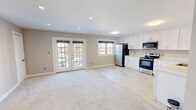 Located at 5867 Poplar Hall Dr in Norfolk, Virginia, this single-floor, 2-bedroom, 1-bathroom home offers a thoughtfully updated interior with a clean, modern aesthetic. The open-concept main living area seamlessly integrates the living room, dining space, and kitchen, creating an airy and connected atmosphere. Light-wood-style tile flooring runs through the kitchen and dining area, while soft carpeting adds warmth to the living and bedroom spaces. French doors in the living room invite natural light and provide outdoor access, complemented by multiple windows that keep the space bright throughout the day.

The kitchen is well-appointed with white shaker-style cabinetry, light countertops, and a full suite of stainless steel appliances, including a refrigerator, electric range, microwave, and dishwasher. Both bedrooms are carpeted and bathed in natural light from single windows, with neutral warm-gray walls lending a calm, versatile feel. The primary bedroom features a mirrored sliding-door closet and dedicated closet space, while the second bedroom includes a closet as well. The bathroom is finished with classic white subway tile from floor to ceiling around the tub, paired with a clean vanity and tile flooring. With five closets throughout, storage is plentiful in this efficiently designed home.