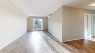 Located at 3142–3148 Jacklin Road in Langford, BC, this thoughtfully designed one-bedroom, one-bathroom unit offers a comfortable and functional living space. The open-concept living and kitchen area is anchored by durable wood-look flooring, neutral warm-toned walls, and generous natural light streaming through a sliding glass door that leads to a private balcony with outdoor views.

The kitchen features contemporary wood-grain cabinetry, light countertops with a clean tile backsplash, a double stainless steel sink, a full suite of black appliances including a refrigerator, range, and dishwasher, along with ample upper and lower storage.

The living area is spacious and airy, equipped with a wall-mounted ductless mini-split unit for year-round climate control. The bedroom offers a comfortable footprint, a large closet with bi-fold doors, and access to natural light. Multiple additional closets throughout the unit provide excellent storage capacity.

The bathroom is clean and practical, with a vanity and sink, and is conveniently positioned within the layout. A dedicated laundry room with full-size side-by-side washer and dryer and overhead shelving adds everyday convenience. The overall aesthetic is modern and neutral, making for a bright, move-in-ready home.