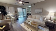 This single-story, one-bedroom, one-bathroom residence offers a cohesive and modern interior highlighted by warm neutral tones throughout. The open-concept living area features rich hardwood-style flooring, a ceiling fan with light fixture, and a sliding glass door that leads to a private balcony — filling the space with natural light and providing a seamless indoor-outdoor connection. The living room flows naturally into a dedicated dining area, making the layout both functional and inviting.

The kitchen is outfitted with white cabinetry, light countertops, black appliances including an electric range and refrigerator, and a tasteful gray subway tile backsplash that adds a contemporary touch.

The bedroom is carpeted for comfort and features a walk-in closet, a window with natural light, and ample space for a full furniture arrangement. A textured ceiling and soft neutral walls contribute to the room's calm, restful atmosphere.

The bathroom is clean and efficiently designed, featuring a tub-shower combination with white tile surround, a single vanity with a white countertop, and a large framed mirror that enhances the sense of space.

Overall, this residence presents a stylish and functional layout with consistent modern finishes, making it an appealing and comfortable living space.