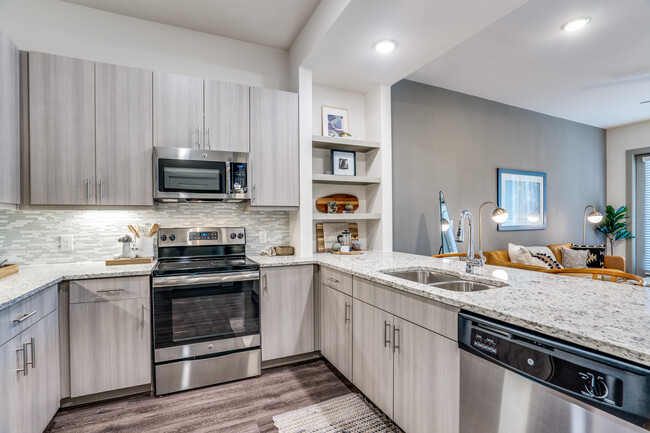 Gray finish package kitchen and dining area with hard surface flooring. - Avalon West Plano