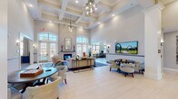 Located at 110 Singh Lane in Cary, NC, this sophisticated single-floor clubhouse offers a thoughtfully designed communal facility. The grand lobby welcomes visitors with soaring coffered ceilings, an eye-catching geometric chandelier, large arched French doors, and abundant natural light. Comfortable seating arrangements and a mounted display screen make the space equally suited for socializing or presentations. Two dedicated conference rooms each feature a solid wood conference table, sleek leather chairs, a large wall-mounted screen, and a distinctive sputnik-style ceiling fixture, ideal for professional meetings. Multiple lounge areas provide intimate gathering spots, each anchored by a fireplace and furnished with stylish upholstered seating. One lounge opens directly to outdoor views of the pool area through floor-to-ceiling arched windows. The fully equipped kitchen area showcases soft blue cabinetry, granite countertops, a white subway tile backsplash, stainless steel appliances, and an ice and water dispenser, offering a well-appointed space for catering and everyday use. A study and library nook features built-in shelving, warm pendant lighting, and bar-height wooden worktables, creating a productive yet inviting environment. Throughout, the interiors are unified by blue-toned carpeting, neutral tones, and refined finishes.