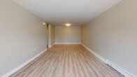 Located at 170 Erb St W in Waterloo, Ontario, this two-storey home offers a thoughtfully designed layout spread across two floors. The main floor features a bright and open living room with large windows that invite an abundance of natural light and offer views of the surrounding mature trees. Light-toned laminate flooring flows consistently throughout both levels, creating a cohesive and clean aesthetic. The kitchen is well-appointed with crisp white shaker-style cabinetry, subway tile backsplash, grey countertops, a double undermount sink with brushed nickel fixtures, and ample storage — all complemented by the same warm wood-look flooring. A dedicated laundry area and staircase connections add to the functional layout of the main floor. Upstairs, three bedrooms provide comfortable accommodation, including a generously sized primary bedroom. Each bedroom benefits from natural light through well-placed windows with outdoor views. The full bathroom is finished to a high standard, featuring floor-to-ceiling marble-effect porcelain tile, a glass-enclosed shower, a bathtub, and bright overhead lighting. Hallways connect each level with ease, and the overall interior palette of warm neutrals and white trim lends the home a clean, modern, and welcoming ambiance.