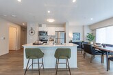 Located at 667 Talbot St in London, Ontario, this 2-bedroom, 2-bathroom residence offers a thoughtfully designed single-floor layout that balances comfort and functionality. The open-concept living and kitchen area serves as the heart of the home, featuring light hardwood-style flooring, recessed lighting, and a large kitchen island with seating — ideal for both casual dining and entertaining. The kitchen is equipped with stainless steel appliances, white cabinetry, and a clean, modern aesthetic. The living room is bright and inviting, with expansive windows dressed in sheer curtains that allow natural light to pour in and offer pleasant outdoor views. A separate dining area provides additional space for meals and gatherings. The spacious primary bedroom features plush carpeting, a large sliding-door closet, and a calm, neutral palette. The second bedroom is equally well-lit, with wrap-around windows that create an airy, versatile space. Both bathrooms are finished in clean white tones — one featuring a sleek glass-door shower with light wood flooring, and the other a full soaker tub with tiled surround. In-unit laundry with a stacked washer and dryer adds everyday convenience. The overall ambiance is modern, bright, and welcoming throughout.