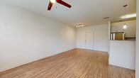 This single-story, two-bedroom unit in Savannah, GA offers a well-organized layout with wood-look flooring running throughout every room, creating a cohesive and easy-to-maintain interior. The combined kitchen and living area forms the heart of the home. The kitchen is outfitted with white shaker-style cabinetry extending to the ceiling, granite-look countertops, and a full suite of stainless steel appliances including a refrigerator, range, microwave, and dishwasher. The adjacent living area is brightened by a glass-paneled exterior door and a large window, admitting generous natural light, and is equipped with a ceiling fan.

The primary bedroom is a comfortable, well-proportioned space featuring dual windows that provide outdoor views and abundant natural light, along with a ceiling fan. It is complemented by a dedicated walk-in closet with wire shelving systems lining multiple walls for organized storage. The second bedroom also includes a window and a double-door closet. Neutral warm-beige walls and consistent wood-look flooring throughout lend the unit a clean, uniform aesthetic well-suited to the Savannah climate.
