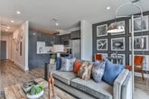 Located steps from Centennial Olympic Park in the heart of Atlanta, this single-floor residence offers a thoughtfully designed living space with modern finishes throughout. The open kitchen is a standout feature, showcasing sleek high-gloss gray cabinetry, white quartz countertops, a white subway tile backsplash, and a full suite of stainless steel appliances including a refrigerator with ice maker, electric range, over-the-range microwave, and dishwasher. Wood-look flooring runs throughout, lending warmth and continuity to each area. The living room is bright and inviting, anchored by floor-to-ceiling sliding glass doors that flood the space with natural light and offer views of the surrounding Atlanta cityscape and greenery. A clean white hallway with recessed lighting and bold dark-paneled doors connects the living areas to the private spaces. The bedroom is styled with a rich, layered aesthetic — textured wall treatments, curated gallery wall art, soft carpeting, and warm accent lighting create a cozy and intimate retreat. The bathroom features a long vanity with ample counter space, a framed mirror, and wood-look flooring, maintaining the home's cohesive modern design. This residence combines contemporary urban style with comfortable, functional living in one of Atlanta's most vibrant neighborhoods.
