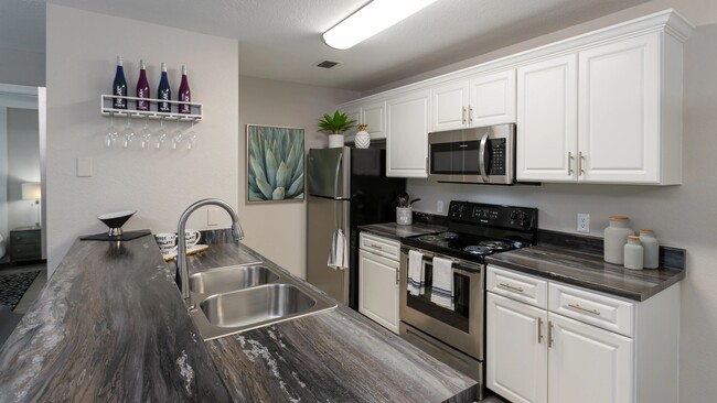 Experience a contemporary kitchen at Soleil Blu Apartments in St Cloud, FL, featuring stainless steel appliances, sleek countertops, custom cabinetry, and stylish finishes. - Soleil Blu Luxury Apartments